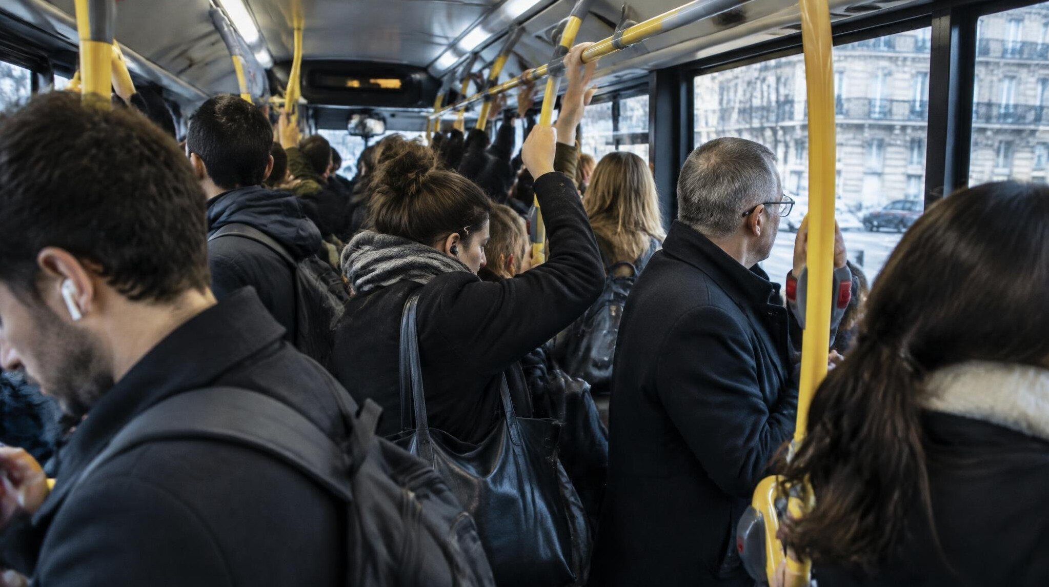 Crowded public bus interior with commuters standing